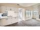 Well-lit kitchen with white cabinets and stainless steel appliances, seamlessly flowing into the living space at 2122 S Victor St # F, Aurora, CO 80014