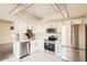 Modern kitchen featuring white cabinetry, stainless steel appliances, and tile flooring, with ample natural light at 2122 S Victor St # F, Aurora, CO 80014