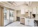 Bright kitchen featuring tile floors, white cabinets, and a sliding glass door to the outside at 2122 S Victor St # F, Aurora, CO 80014