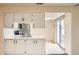 Bright kitchen featuring white cabinets, stainless steel appliances, and a sliding glass door at 2122 S Victor St # F, Aurora, CO 80014