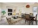 Bright living room featuring a brick fireplace, dining area, and comfortable seating at 2122 S Victor St # F, Aurora, CO 80014