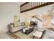 Open-concept living room with a large sofa, coffee table, and staircase to the upper level at 2122 S Victor St # F, Aurora, CO 80014