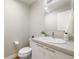 Powder room featuring a toilet, sink, and a mirror at 1340 W 68Th Ave, Denver, CO 80221
