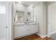 Bright bathroom featuring double sinks with sleek cabinets, modern mirrors, and hardwood floors at 1340 W 68Th Ave, Denver, CO 80221