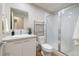 Clean bathroom with a glass enclosed shower, modern vanity with sink, and open shelving for storage at 1340 W 68Th Ave, Denver, CO 80221