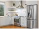 Updated kitchen with stainless steel oven, refrigerator and floating shelves at 1340 W 68Th Ave, Denver, CO 80221