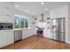 Well-lit white kitchen features stainless steel appliances, open shelving and many windows at 1340 W 68Th Ave, Denver, CO 80221