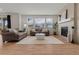 Bright living room with a fireplace, hardwood floors, neutral paint, and plentiful natural light from the large windows at 27307 E Costilla Pl, Aurora, CO 80016