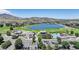 Aerial view highlighting the community's amenities, including a pool, golf course, lake, and clubhouse at 15789 Sandtrap Way, Morrison, CO 80465