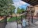 Back porch with table and chairs overlooking the backyard, perfect for entertaining at 15789 Sandtrap Way, Morrison, CO 80465
