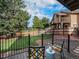 Back porch featuring green backyard and two chairs with patterned cushions at 15789 Sandtrap Way, Morrison, CO 80465