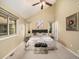 Primary bedroom featuring vaulted ceilings, soft lighting, ensuite bath, and cozy carpet at 15789 Sandtrap Way, Morrison, CO 80465