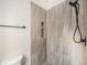 Contemporary shower showcasing gray tiled walls, built-in shelves, and a modern shower head with a black finish at 15789 Sandtrap Way, Morrison, CO 80465