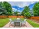 Backyard featuring patio set, manicured lawn, and plenty of shade from mature trees and the blue sky at 9717 Castle Ridge Cir, Highlands Ranch, CO 80129