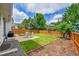 Green backyard with a wooden fence, patio set on brick pavers, and garden plots available at 9717 Castle Ridge Cir, Highlands Ranch, CO 80129