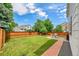 Green backyard with a wooden fence, patio set on brick pavers, and ample green lawn at 9717 Castle Ridge Cir, Highlands Ranch, CO 80129