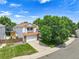 Aerial view of the home showing mature trees, lush lawn, ample driveway, and privacy fence at 9717 Castle Ridge Cir, Highlands Ranch, CO 80129