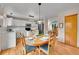 Bright kitchen with modern appliances, wood floors, and a charming dining area with seating for four at 9717 Castle Ridge Cir, Highlands Ranch, CO 80129