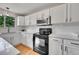 Modern kitchen featuring white cabinets, subway tile backsplash, stainless microwave and black range at 9717 Castle Ridge Cir, Highlands Ranch, CO 80129
