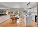 Open-concept kitchen and dining area with wood floors, white cabinets, and modern appliances at 9717 Castle Ridge Cir, Highlands Ranch, CO 80129