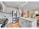 Kitchen with island, stainless refrigerator and hardwood floors leading to staircase at 9717 Castle Ridge Cir, Highlands Ranch, CO 80129