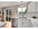 Well-lit kitchen with stainless dishwasher, white countertops and sink with goose neck faucet at 9717 Castle Ridge Cir, Highlands Ranch, CO 80129