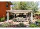 Brick backyard featuring a pergola-covered outdoor dining area and tranquil water fountain at 1275 N Franklin St, Denver, CO 80218