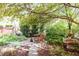 Landscaped garden featuring a stone fountain, brick pathway, and a shaded seating area at 1275 N Franklin St, Denver, CO 80218