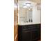 Bathroom with dark vanity, granite countertop, chrome fixtures, and tiled shower at 1275 N Franklin St, Denver, CO 80218