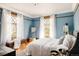 Comfortable bedroom with wood floors, two bright windows, and a padded bench at 1275 N Franklin St, Denver, CO 80218