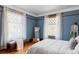Cozy bedroom featuring blue walls, hardwood floors, and two large windows with lots of natural light at 1275 N Franklin St, Denver, CO 80218