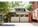 Two-car garage with upper window, trimmed doors, and mature vines at 1275 N Franklin St, Denver, CO 80218