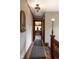 Hallway with hardwood floors, dark trim, and a patterned carpet runner leads to the home office at 1275 N Franklin St, Denver, CO 80218