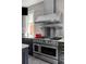 Spacious kitchen features a stainless steel range with a large custom hood and subway tile backsplash at 1275 N Franklin St, Denver, CO 80218