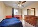 Bedroom with wood-look floors, blue bedspread, and dresser with mirror at 2551 S Carson Way, Aurora, CO 80014
