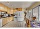 Functional kitchen featuring light wood cabinets, white appliances, and tile flooring at 2551 S Carson Way, Aurora, CO 80014