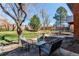 Outdoor patio with seating, a lush lawn, mature trees, and privacy fence for backyard entertaining at 11651 E Yale Way, Aurora, CO 80014