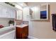 Cozy bathroom with a vanity, decorative mirror and granite backsplash at 11651 E Yale Way, Aurora, CO 80014