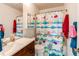 The bathroom features a sink, toilet, and shower with a vibrant, playful curtain at 11651 E Yale Way, Aurora, CO 80014