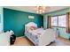 Cozy bedroom with unique colorful decor, bright accent wall, and natural light from the window at 11651 E Yale Way, Aurora, CO 80014