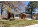 Brick home featuring attached garage, well-maintained landscaping, and mature trees enhancing curb appeal at 11651 E Yale Way, Aurora, CO 80014