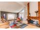 Cozy living room with hardwood floors, a red brick fireplace, and large windows with natural light at 11651 E Yale Way, Aurora, CO 80014