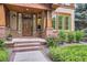 Close-up of a home's front entrance with a striking wood door, brick pillars, and well-maintained landscaping at 1410 S Elizabeth St, Denver, CO 80210