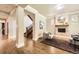 Bright living room with hardwood floors, cozy fireplace, and staircase; adjacent to a doorway and hallway at 1410 S Elizabeth St, Denver, CO 80210