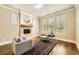 Elegant living room featuring a fireplace, plantation shutters, hardwood floors, and two stylish chairs at 1410 S Elizabeth St, Denver, CO 80210
