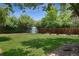 A spacious backyard featuring a shed, lawn, fence, greenery, and garden beds on a sunny day at 1111 Kearney St, Denver, CO 80220