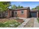 Charming brick home featuring a well-maintained front yard and a one-car attached garage at 1111 Kearney St, Denver, CO 80220