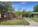 Well-kept brick home with a dark roof, complemented by mature trees and a driveway leading to the garage at 1111 Kearney St, Denver, CO 80220