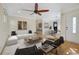 Bright living room with hardwood floors, white sofa, and stylish black accent chairs under a ceiling fan at 1111 Kearney St, Denver, CO 80220