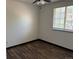 A clean, minimalist bedroom featuring a window, wood-look flooring and ceiling fan at 8571 S Estes St, Littleton, CO 80128